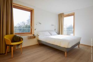 Un pat sau paturi într-o cameră la La Ferme Des Ailleurs