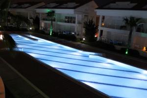 an empty swimming pool at night in a building at Wonderful 3 bed duplex in sought after prime community in Side