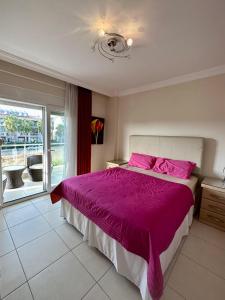a bedroom with a large bed with pink sheets and a window at Wonderful 3 bed duplex in sought after prime community in Side