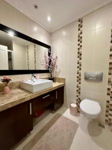 a bathroom with a sink and a toilet and a mirror at Wonderful 3 bed duplex in sought after prime community in Side