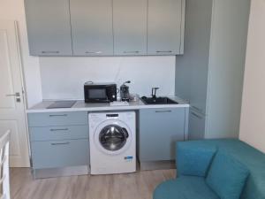 a kitchen with a washing machine and a sink at Seaview Residence in Constanţa +20 photos
