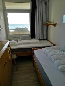 1 Schlafzimmer mit 2 Betten und einem großen Fenster in der Unterkunft Strandhotel Wohnung 30 in Dahme