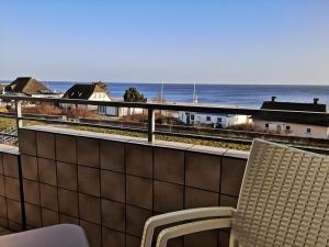 einen Balkon mit einem Stuhl und Meerblick in der Unterkunft Strandhotel Wohnung 30 in Dahme