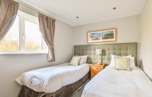 due letti in una camera da letto con finestra di Swallow Lodge with Hot Tub, dogs welcome sleeps 8, Great resort Facilities a Padstow Altre 38 foto