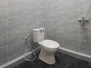 een badkamer met een toilet met een slang bij RedDoorz Syariah near KBC Batam Centre in Bagam