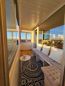 奧格斯堡的住宿－Stylische Sunset-Wohnung，阳台配有沙发、桌子和窗户。