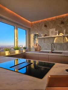 a kitchen with a sink and a large window at Stylische Sunset-Wohnung in Augsburg