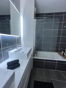 łazienka z umywalką, wanną i toaletą w obiekcie Superbe appartement cosy avec jacuzzi w mieście Francheville