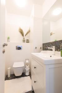 a white bathroom with a toilet and a sink at Didi's Central Designer Apartments in Sofia +39 photos
