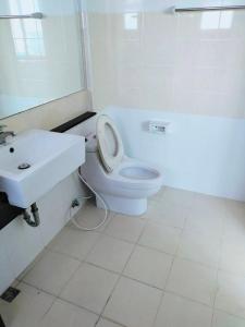 a white bathroom with a toilet and a sink at 98/61 home in Ban Khlong Prawet