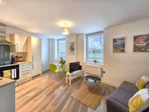 a living room with a couch and a table and a kitchen at The Post House One in Gloucester