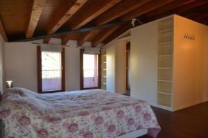 1 dormitorio con 1 cama en una habitación con ventanas en Due Torri Terrace apt, en Noale