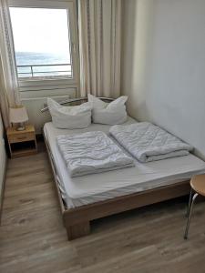 a bed in a room with a large window at Strandhotel Wohnung 68 in Dahme