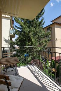 a balcony with a tree and a wooden bench at Didi's Central Designer Apartments in Sofia