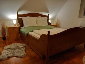 sypialnia z dużym drewnianym łóżkiem i zielonym kocem w obiekcie Boglárka Vendégház Tiszalök w mieście Tiszalök