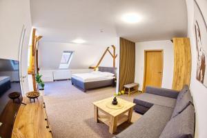 a living room with a couch and a bed at Hotel a Restaurace Růže in Podbořany