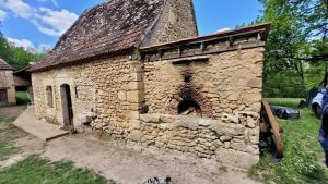 un antiguo edificio de piedra con un horno de ladrillo en la meyrolette, en Mauzens-et-Miremont