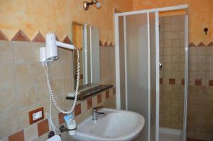 a bathroom with a sink and a shower with a mirror at Hotel Sant'elene in Dorgali