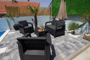 a patio with three chairs and a table and sidx sidx sidx at Summer House with Heated Swimming Pool in Mostar