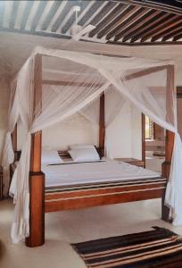 a bed with a canopy in a room at Al-reidy House in Lamu