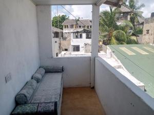 a balcony with a bench on the side of a building at Al-reidy House in Lamu