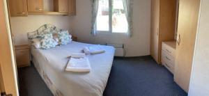 Un dormitorio con una cama con dos bandejas. en 2 bedroom cosy caravan en Borth