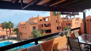 a balcony with a view of a building and a swimming pool at Jardines, piscina y mar in Estepona