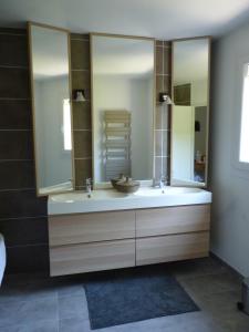 uma casa de banho com um lavatório e um espelho grande em LA CIVADE em La Ciotat