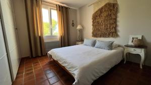 a bedroom with a white bed and a window at LA CIVADE in La Ciotat +24 photos
