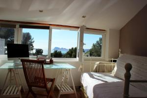 a bedroom with a bed and a desk with a computer at LA CIVADE in La Ciotat