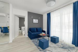 Una sala de estar con un sofá azul y una mesa. en Szymony Apartments Zakopane with SPA & Parking by Noclegi Renters, en Zakopane 66 fotos más