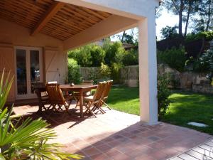 a patio with a wooden table and chairs at LA CIVADE in La Ciotat