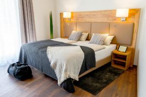 a bedroom with a large bed with a wooden headboard at Landhotel Lebensart in Xanten