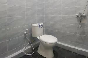 een badkamer met een toilet met een slang bij RedDoorz Syariah near KBC Batam Centre in Bagam