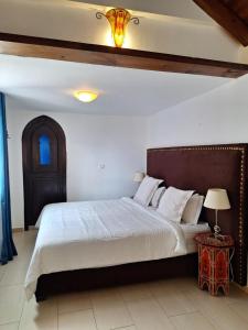 a bedroom with a large bed with a wooden headboard at Dar Gabriel in Chefchaouen