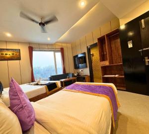 een hotelkamer met 2 bedden en een plafondventilator bij Hotel Runway Inn in Pura Raghunāth