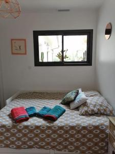 a bed with four pillows on it with a window at La Z family in Lacanau