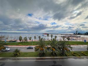 uitzicht op een straat met palmbomen en een waterlichaam bij Mihman Hotel in Tuzla