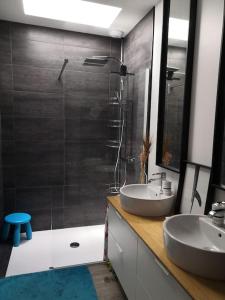 a bathroom with two sinks and a glass shower at La Z family in Lacanau