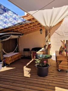 a wooden deck with a bed and an umbrella at La Z family in Lacanau