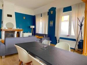 - un salon bleu avec une table et un canapé dans l'établissement Maison Cosy 6 chambres 2 SDB toute commodité, à Roubaix