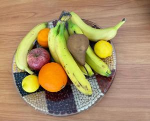 a bowl of fruit with bananas apples oranges and lemons at Comfortable house with terrace close to Vevey and lake Geneva in Attalens