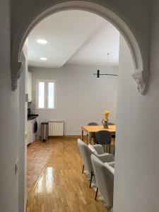 um arco que conduz a uma sala de estar com mesa e cadeiras em Bonito piso a 500m de la Catedral em León