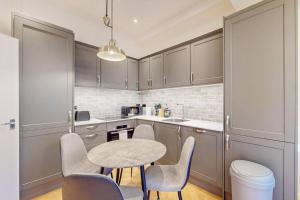 a kitchen with a table and chairs in a kitchen at Stunning 3BD flat in Kilburn with an outdoor area in London