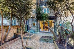 a house with trees in front of a building at Stunning 3BD flat in Kilburn with an outdoor area in London