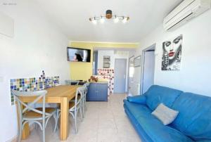 uma sala de estar com um sofá azul e uma mesa em Agréable appartement au cœur de Nerja em Nerja