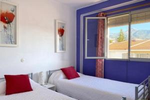 um quarto com 2 camas e uma janela em Agréable appartement au cœur de Nerja em Nerja