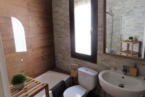 ein Badezimmer mit einem WC, einem Waschbecken und einem Spiegel in der Unterkunft Bonito piso a 500m de la Catedral in León