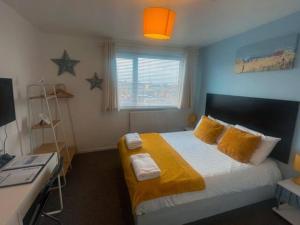 um quarto com uma cama com lençóis amarelos e estrelas em The Chedburgh em Whitley Bay