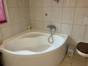 a bath tub in a bathroom with a toilet at Comfortable house with terrace close to Vevey and lake Geneva in Attalens